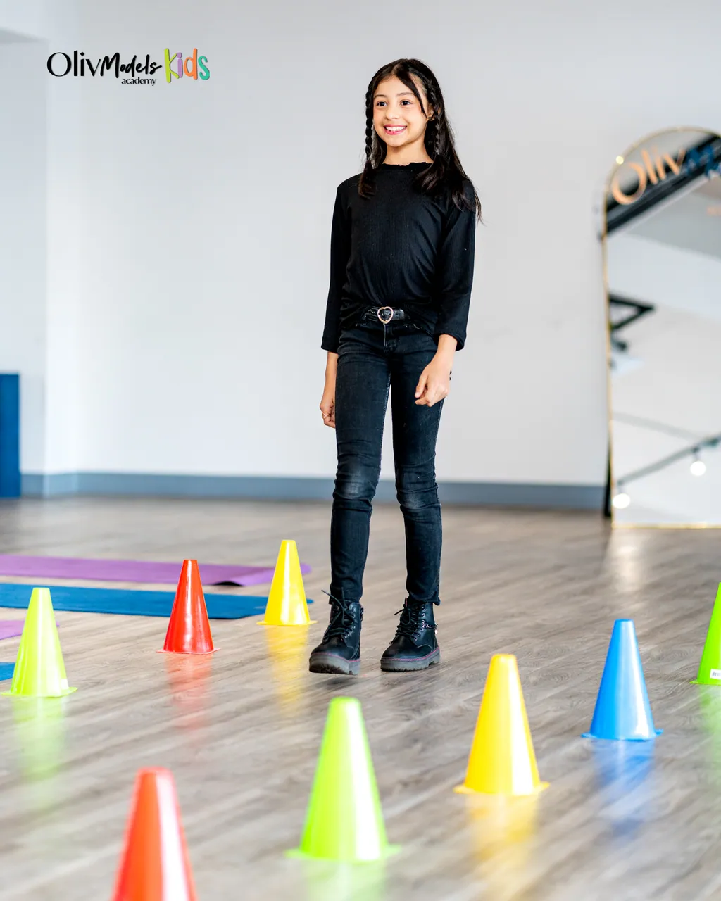 Talento de Oliv Models Kids entre conos de colores en sala de entrenamiento