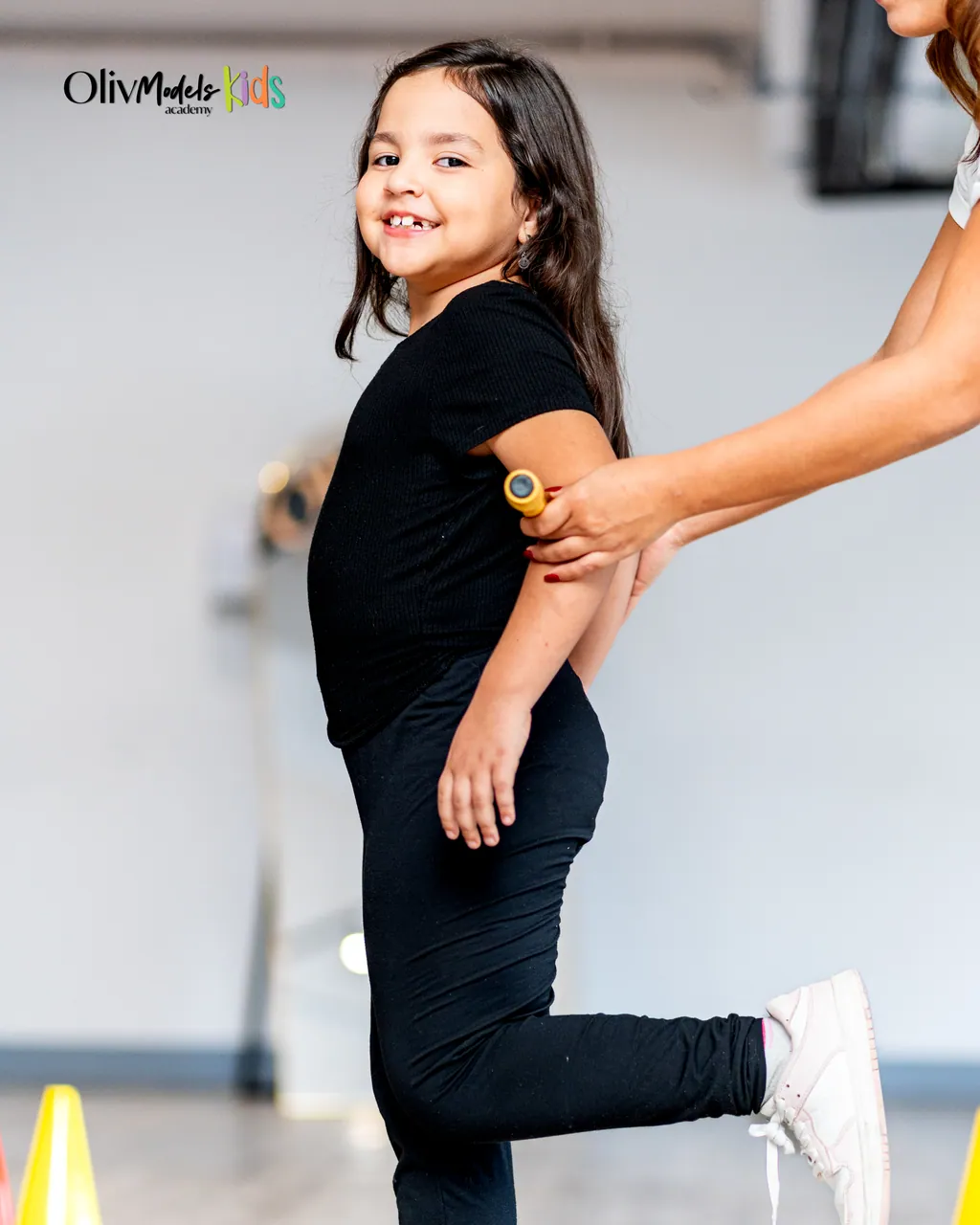 Sesión psicomotriz: coach guiando a una pequeña talento en su pasarela